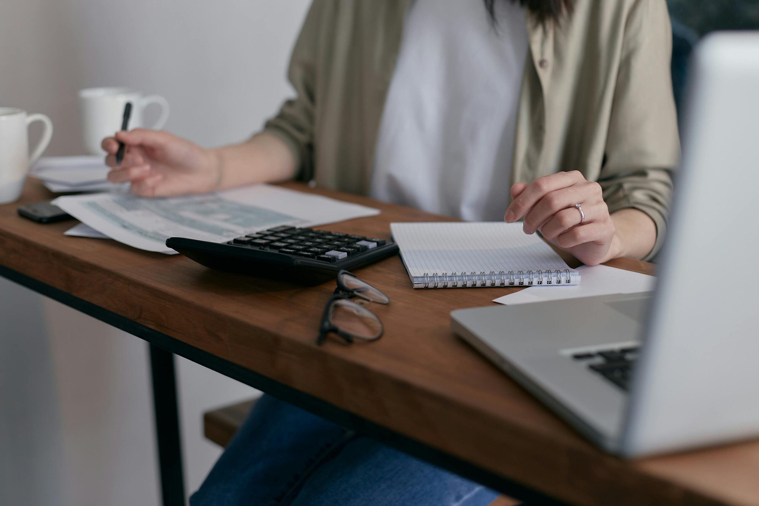 Asian Woman working with calculator in desk | Solutionariez